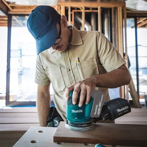 Makita DBO180Z Cordless Orbital Sander in use.